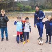 Oscar Lyons (left) with his football training group and Arsenal footballer Myles Lewis-Skelly (right) in Stationers Park
