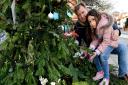 Richard and Gabriella Ratcliffe put a decoration on the Free Nazanin Christmas Tree outside Budgens in Belsize Village.