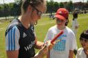 England's Becky Grundy signs an autograph for Maddy Smith from Kentish Town at Hampstead CC