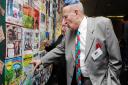 Survivor Jack Hecht, 86, examines his quilt square, created by grandsons Josh and Noah Hecht.