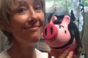 Emma Thompson posing with a Pigs4Kids piggy bank.