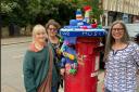 Caroline Chan with fellow knitters ,Catty and Tracey at the post-box in Belsize Park