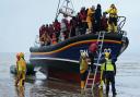 A group of people, thought to be migrants, being escorted to shore by a local lifeboat in Kent.