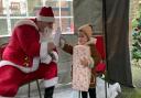 Lali, 2, giving Santa a high five thank you for her gift
