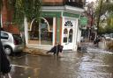 People clearing out drains following flash flood in South End Green