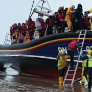 A group of people, thought to be migrants, being escorted to shore by a local lifeboat in Kent.