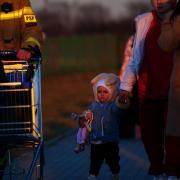 A young girl from Ukraine walks with her family as they cross the border point from Ukraine into Medyka, Poland