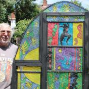 Temple Fortune artist Michael Berg with his stained glass window made from chicken wire