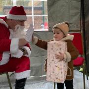Lali, 2, giving Santa a high five thank you for her gift