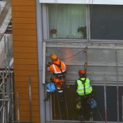 Workmen removing cladding from a block of flats in Paddington in December