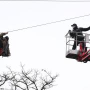 An enforcement officer approaches a HS2 Rebellion protester on a zip line