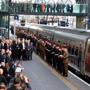 100 serving and veteran military personnel line the platform as the specially liveried Class 91 locomotive For The Fallen arrives at the paltform before a short remembrance service. Picture: Polly Hancock