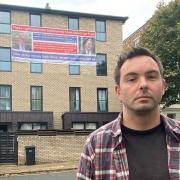 Daniel Bruce and two other first-time buyers have hung a huge banner on their crumbling block of flats in Agar Grove, Camden Town, saying government failures have cost them millions, so the government should bail them out