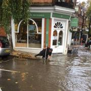 People clearing out drains following flash flood in South End Green