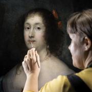 English Heritage conserver Alice Tate-Harte puts the finishing touches to a restored portrait of Diana Cecil, Countess of Elgin.