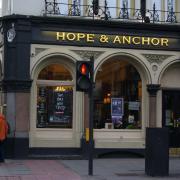 A dispute over who would run The Hope pub theatre has resulted in the  management board resigning but landlords Greene King pledge it will continue to operate.